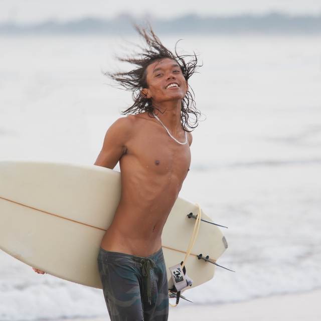 Молодой человек с доской для серфинга